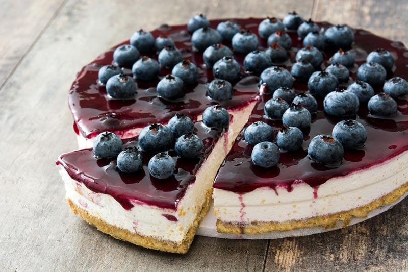 Displaying cheesecake made of no bake gluten free cookie crust with cheesecake filling and blueberry topping
